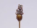 a small statue of a man sitting on top of a wooden stick
