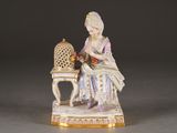 a figurine of a woman sitting on a chair