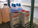 three bottles of liquid sitting on a shelf in a store