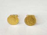 a pair of gold coin cufflinks on a white surface