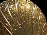a close up of a gold shell on a black background