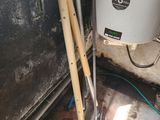 a picture of a water heater and tools in the corner of a room
