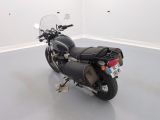 a black motorcycle parked in a room with a white wall
