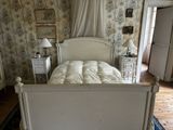 un lit blanc dans une chambre à coucher au papier peint à motifs floraux