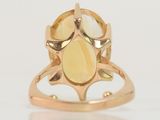 a close up of a ring with a yellow stone in it