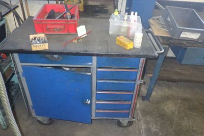 un établi bleu sur lequel sont posés des outils, dans un garage