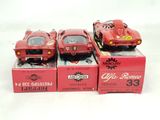 three red toy cars sitting on top of boxes on a white surface