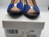 des chaussures bleues et noires posées sur une boîte, sur une surface blanche