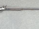 un pistolet posé par terre à côté d'un bout de papier