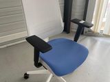 une chaise de bureau bleue et blanche dans un coin de la pièce
