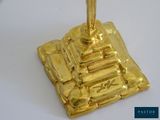 a gold plate with a candle on top of it