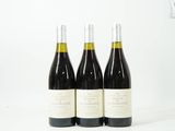 trois bouteilles de vin sont posées sur une surface blanche