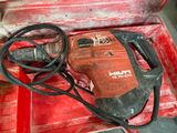 a red tool box with a drill and a cord in it