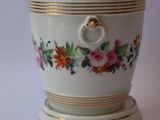 a white cup with a gold rim and a flower design on it