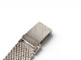 a close up of a metal bracelet on a white surface