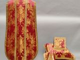une photo d'une étole de prêtre rouge et or et d'une chaise