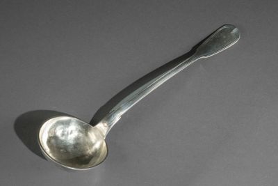 une cuillère en argent avec un manche de cuillère sur une table