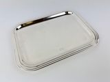 a set of four silver trays on a white surface