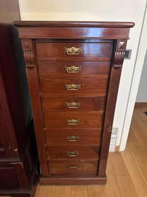 une commode ancienne en bois, dotée de poignées et de boutons en laiton