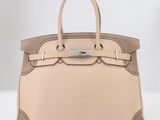 un sac à main en cuir beige muni d'une boucle métallique sur la poignée