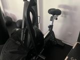 un vélo d'appartement noir sur lequel est posé un sac noir