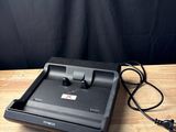 a close up of a laptop on a wooden table with a charger