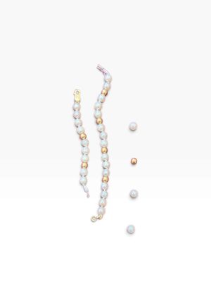 a close up of a pair of earrings with pearls on a white surface