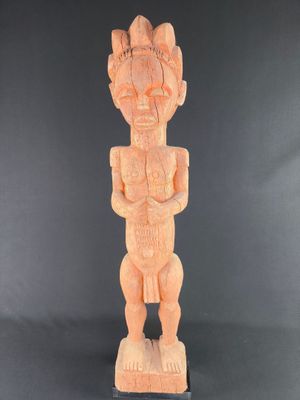 a wooden statue of a man standing on a black surface