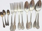 a lot of silver spoons and forks on the table