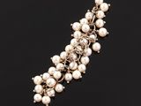 a close up of a pearl bracelet on a black surface