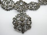 une photo d'un collier en argent orné d'un motif floral