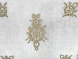 un gros plan sur une nappe blanche ornée de broderies dorées