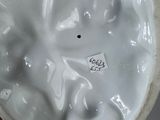 a close up of a white vase on a table