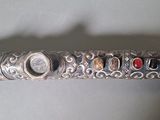 a close up of a silver pen with a lot of beads on it