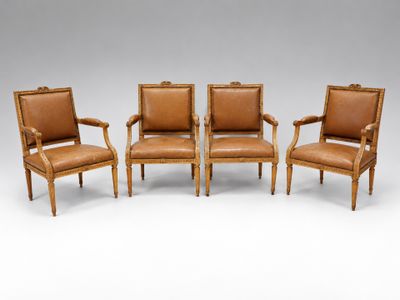 a set of four chairs with leather upholstered back and arms