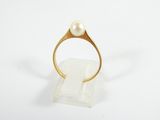 a close up of a gold ring with a pearl on it