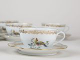 three cups and saucers sitting on a white table