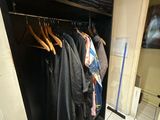 une photo d'un placard avec des vêtements sur des cintres