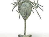 sculpture représentant une tête, réalisée à partir de bâtons et de brindilles, posée sur un socle