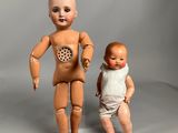 two dolls that are standing next to each other