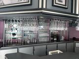 un bar avec de nombreux verres à vin sur les étagères
