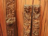 two wooden pillars with carvings on them in a room