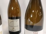 three bottles of wine are lined up on a white surface