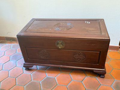 a small wooden chest sitting on a tiled floor