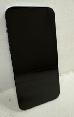un téléphone portable noir posé sur une surface blanche