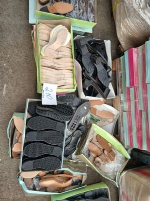 de nombreuses paires de chaussures dans des cartons posés par terre