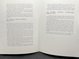an open book sitting on top of a table next to a black background