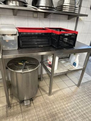 une grande poubelle en métal posée sur le plan de travail de la cuisine