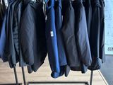 a lot of jackets hanging on a rack in a store