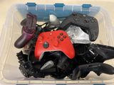 un bac en plastique rempli de différentes sortes de manettes de jeux vidéo